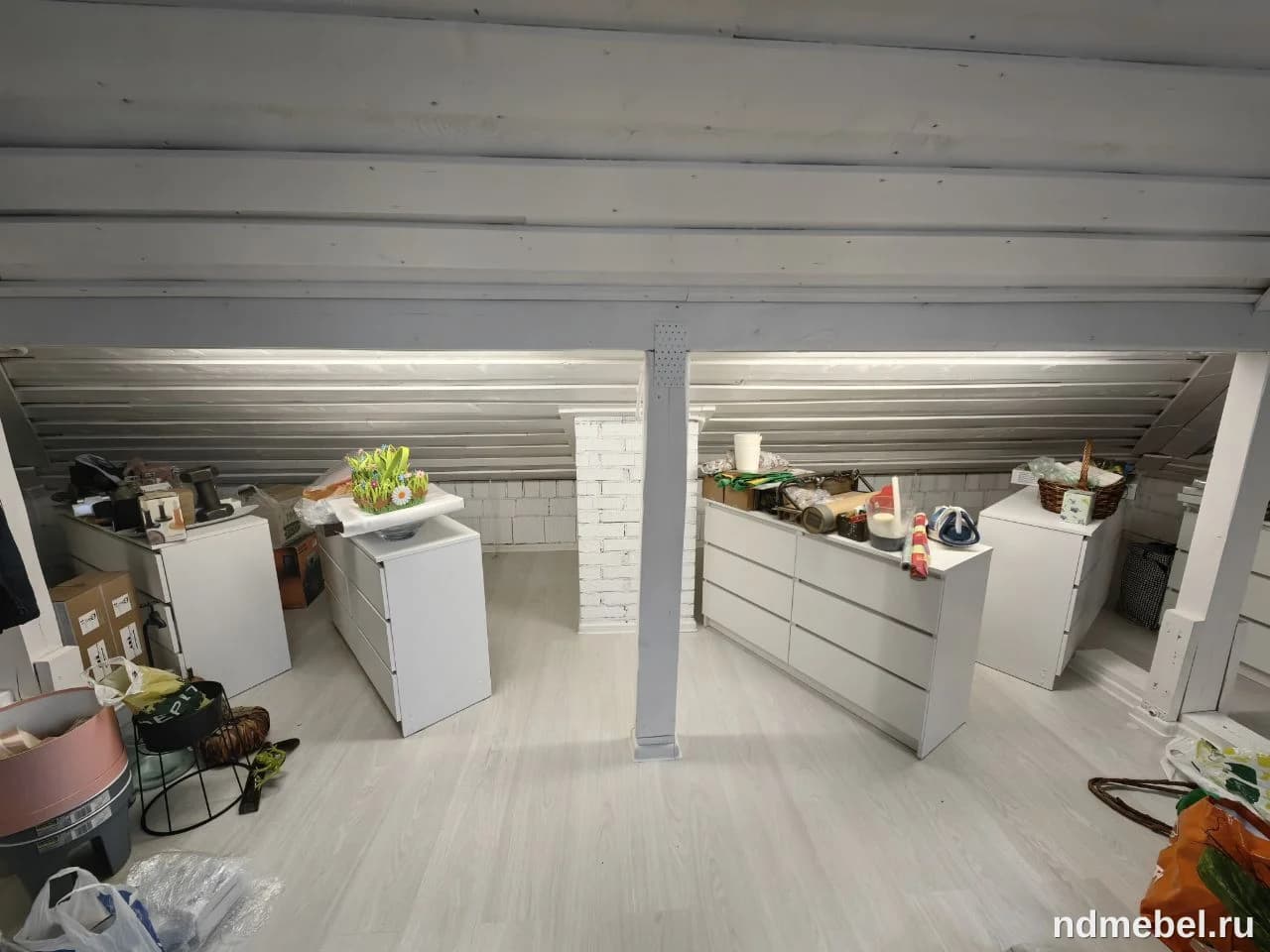 В интерьере мансардного помещения представлены белые комоды из, предположительно, ЛДСП или МДФ, выполненные в современном минималистичном стиле.
Эта модульная мебель используется здесь как система хранения в неоформленном пространстве.