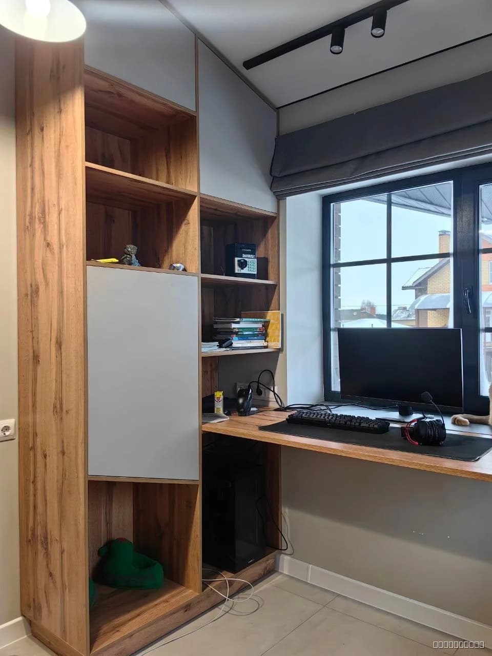 Современный рабочий стол с полками, выполненный из натурального дерева и белых панелей, в минималистичном стиле.